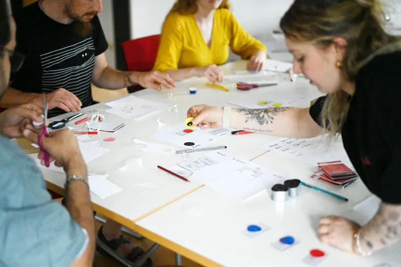 Workshop Impressionen: Die Product Ownerin beugt sich über den Tisch